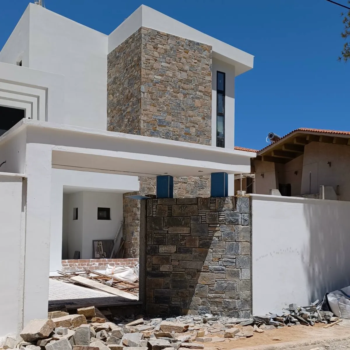 Κατοικία με πέτρινη πρόσοψη και λευκούς όγκους